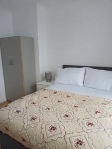 a bedroom with a bed with a patterned blanket on it at Time Space Bliss in Dagenham Dock