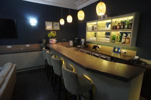 a bar in a restaurant with a long counter and chairs at Applewood Hotel in Bournemouth