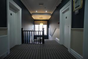a hallway with blue walls and a stairway at Applewood Hotel in Bournemouth