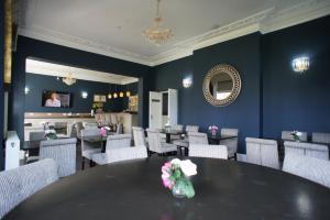 a dining room with a table and chairs and a mirror at Applewood Hotel in Bournemouth