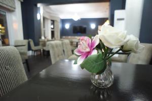 a vase of flowers on a table with roses at Applewood Hotel in Bournemouth