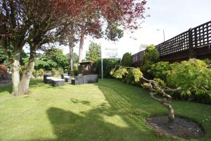 a park with a tree and a sign in the grass at Applewood Hotel in Bournemouth