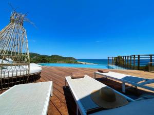 una terraza con bancos y vistas al océano. en Maison Bord'eau, en Sainte-Lucie de Porto-Vecchio