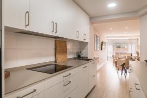 una cucina con armadi bianchi e una sala da pranzo di Apartamento en Llanes a Llanes