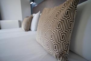 a bed with a brown and white pillow on it at Applewood Hotel in Bournemouth