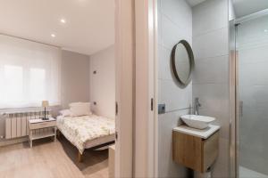 un bagno con un letto, un lavandino e uno specchio di Apartamento en Llanes a Llanes Altre 31 foto