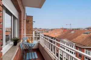 un balcone con tavolo e vista sulla città di Apartamento en Llanes a Llanes