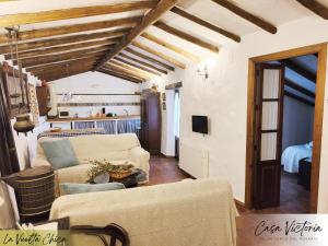 a living room with two couches and a kitchen at Conjunto Rural Casa Victoria in Villaluenga del Rosario
