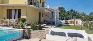 a villa with a swimming pool and a house at Villa Korta Regina in Ston