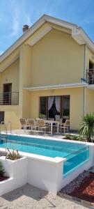 a house with a swimming pool in front of a house at Villa Korta Regina in Ston