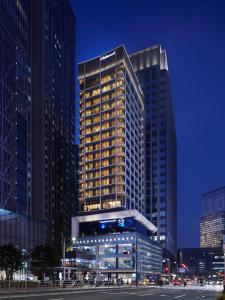 a tall building in a city at night at Oakwood Premier Tokyo in Tokyo
