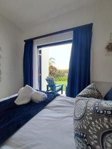 a bedroom with a bed and a large window at Easy Breezy at 18 Thira Santorini in Ballito +33 photos