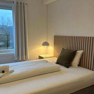 a bedroom with a large bed with a window at Selvbetjent leilighetshotell på Ålgård in Ålgård