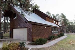 パゴサ・スプリングスにあるMountain Home with Hot Tubのガレージ付きの大きな木造家屋