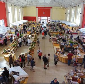 un grupo de personas caminando por un mercado de agricultores en La Villa Bis, en Vesoul
