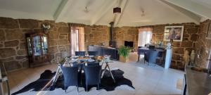 a living room with a table and a stone wall at Quinta da Adarnela in Lagares da Beira