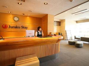 a woman talking on a cell phone at a hotel lobby at Juraku Stay Niigata in Niigata