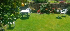 two chairs and a table in a yard at Apartamento Flor de Luna in Santillana del Mar