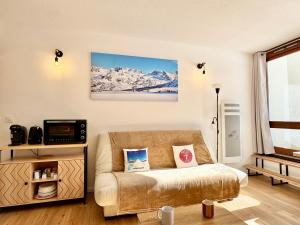 una sala de estar con sofá y montañas cubiertas de nieve en 2 Pièces ISOLA 2000 - FRONT DE NEIGE, en Isola 2000