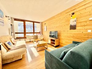 Una sala de estar con un sofá y un televisor. en 2 Pièces ISOLA 2000 - FRONT DE NEIGE, en Isola 2000