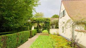 a garden with a walkway next to a building at Boutique hotel-restaurant De Lindehoeve in Tessenderlo