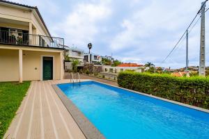 a swimming pool in front of a house at Casa Dolce Vita in Ponta do Sol