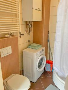 a bathroom with a washing machine and a toilet at Studio City apartment Sweet Panda in Zagreb