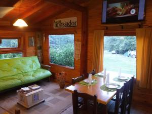 a living room with a table and a green couch at Vulcanche in Villa Traful