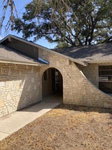 a stone house with a stone wall and a door at Hidden Haven in Canyon Lake