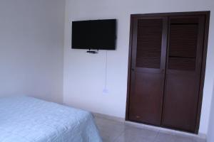 カリにあるCasa Esperanzaのベッドルーム1室(ベッド1台、壁掛けテレビ付)
