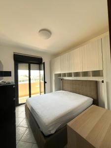 Un dormitorio con una cama grande y una ventana. en Rudy Apartment, en San Salvo