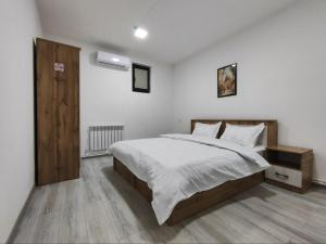 a bedroom with a large bed with white sheets at The RISE HST in Tashkent