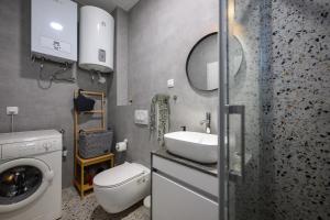 a bathroom with a sink and a washing machine at Roris House in Povljana