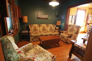 a living room with two chairs and a couch and a table at Fairmount Bed & Breakfast in Basswood