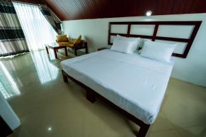 a bedroom with a large bed with white sheets and pillows at Alankara St Clair Retreat Talawakelle in Talawakele +22 photos