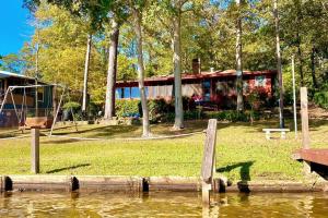 une maison située au bord d'un plan d'eau dans l'établissement Newly Remodeled Lakehouse on Private Lake sleeps 8, à Woodville
