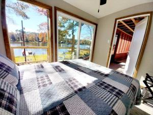 une chambre avec un lit et une grande fenêtre dans l'établissement Newly Remodeled Lakehouse on Private Lake sleeps 8, à Woodville