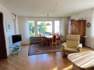 a living room with a table and chairs and a television at Ferienwohnung Seestraße Ost in Immenstaad am Bodensee