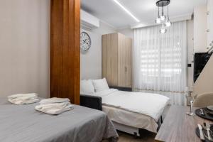 a bedroom with two beds and a clock on the wall at Cozy DownTown Apartment in Xanthi
