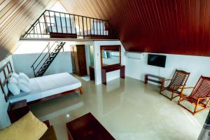 a living room with a staircase and a couch and chairs at Alankara St Clair Retreat Talawakelle in Talawakele