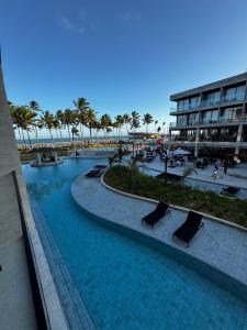 vista su una piscina con palme e su un edificio di Porto Alto Resort a Ipojuca