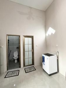 a bathroom with a shower and a toilet in a room at D Three Houze Banyuwangi 3Br in Dadapan +10 photos