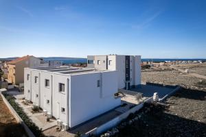 a large white building with the ocean in the background at Roris House in Povljana