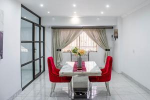 a dining room with a table and red chairs at Ashburton Stays in Pietermaritzburg
