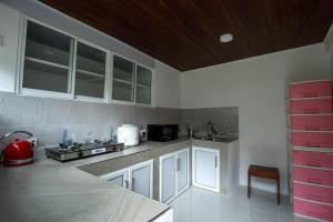 a kitchen with white cabinets and a red appliance at Alankara St Clair Retreat Talawakelle in Talawakele