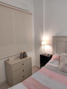 a bedroom with a bed and a dresser and a window at San Nicolas Apartaments in Fuengirola