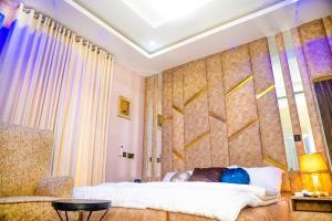 a bedroom with a bed and a wall with yellow arrows at Kay&M Homes in Garki