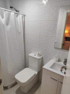 a white bathroom with a toilet and a sink at San Nicolas Apartaments in Fuengirola