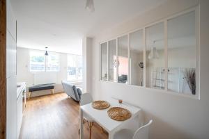 ル・プレシ・ロバンソンにあるAppartement cosy avec belle terrasseの白いテーブルと椅子のある白いダイニングルーム