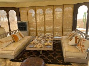 a living room with two couches and a table at Agafay Desert Stay in Guertsdar